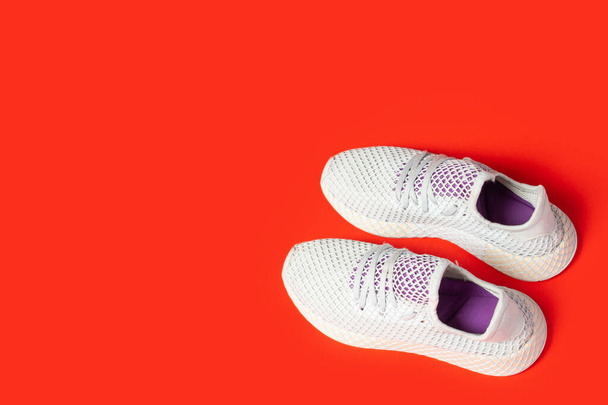 Sports sneakers on a red background. Concept of sport, fashion. Top view, flat lay. - Foto, imagen