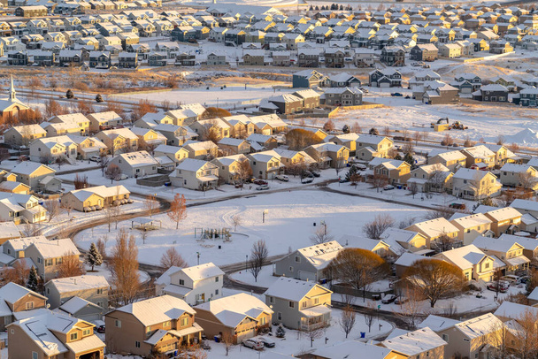 Aerial view of homes in snowy Utah Valley neighborhood at sunset in winter - Photo, Image