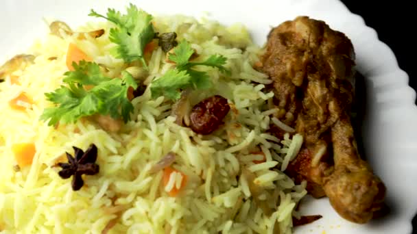 Kuřecí Biryani ukazuje kus nohy - Je to vynikající recept rýže Basmati smíchané s pikantní marinované kuře v misce. Podává se v misce nebo talíři. Selektivní zaměření - Záběry, video