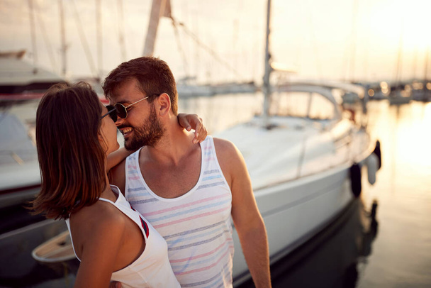 Couple enjoying by the sea.Happy woman kissing man on dock during sunset. - Φωτογραφία, εικόνα