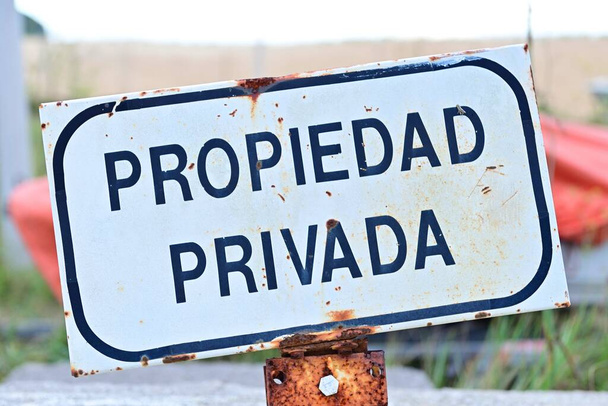An old rusty sign in Spanish that translates "Private Property" - Фото, зображення