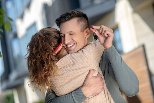 Young couple holding the key from new house and hugging - Photo, image