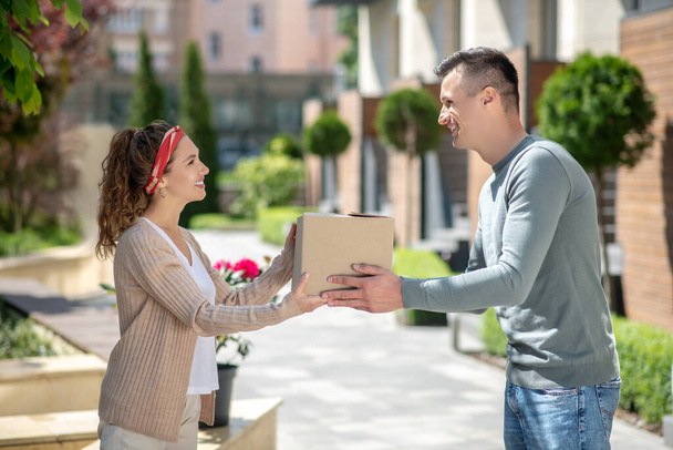 Smiling woman passing a box to her husband - Foto, Imagem