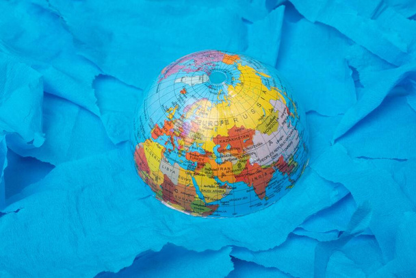 A high angle shot of the globe on a blue surface - Fotó, kép