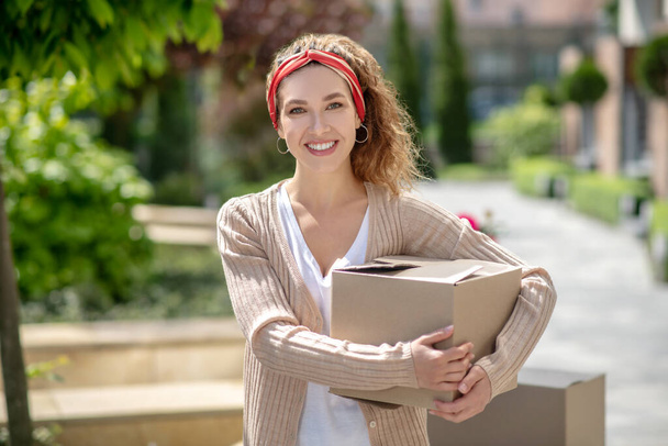 Young pretty woman holding a box and smiling - Photo, Image