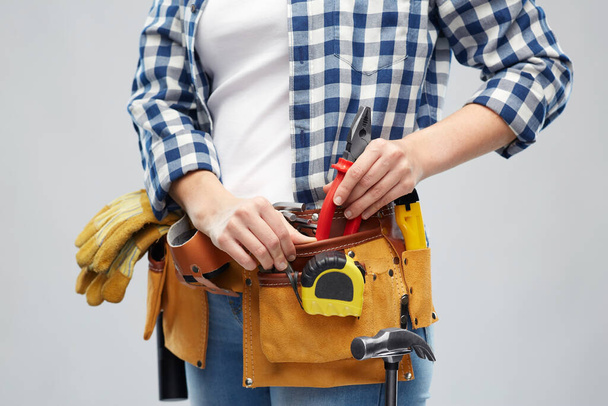 woman or builder with working tools on belt - Φωτογραφία, εικόνα