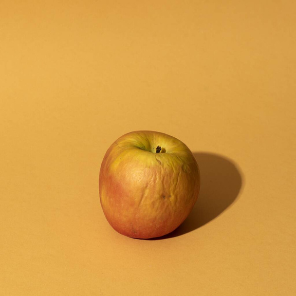 A closeup shot of an apple on a yellow background - Fotoğraf, Görsel