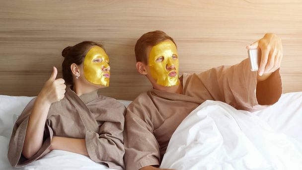 familia con mascarillas hace selfie en cama suave en el hotel
 - Foto, imagen