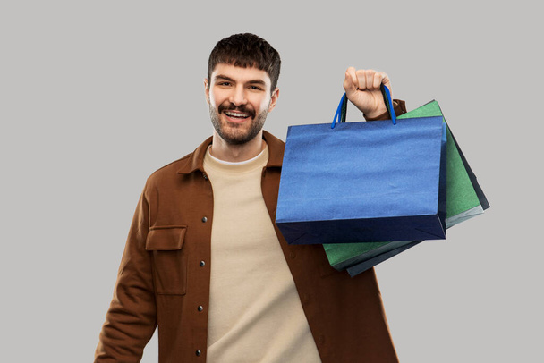 happy smiling young man with shopping bags - Фото, изображение