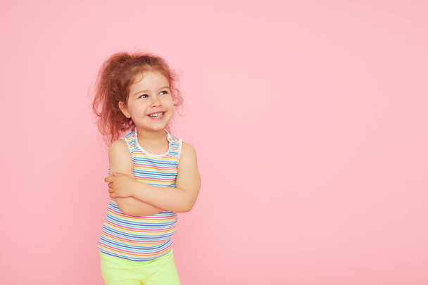 Portret uroczej dziewczynki ze śnieżnobiałym uśmiechem i zdrowymi zębami na różowym tle. patrząc w kamerę i śmiejąc się. Stomatologia dla dzieci - Zdjęcie, obraz