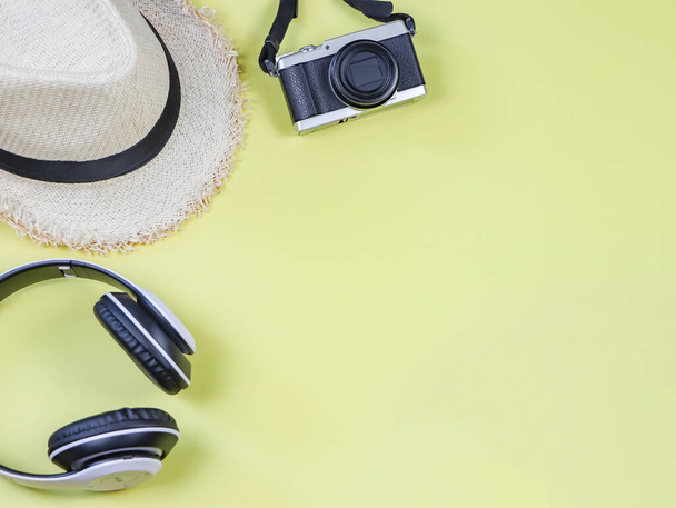 Concept de voyage et de passe-temps, vue de dessus ou pose plate d'accessoires de voyage, appareil photo, casque et chapeau sur fond jaune avec espace de copie
. - Photo, image