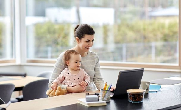 mother with baby and laptop working at home office - Φωτογραφία, εικόνα