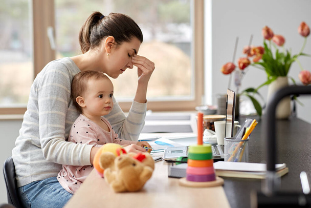 tired mother with baby working at home office - Φωτογραφία, εικόνα