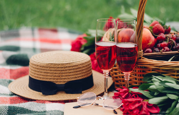 Details zum Picknick, Gläser mit Rotwein auf Karo, Beeren und Obstgläser, Bücher - Foto, Bild