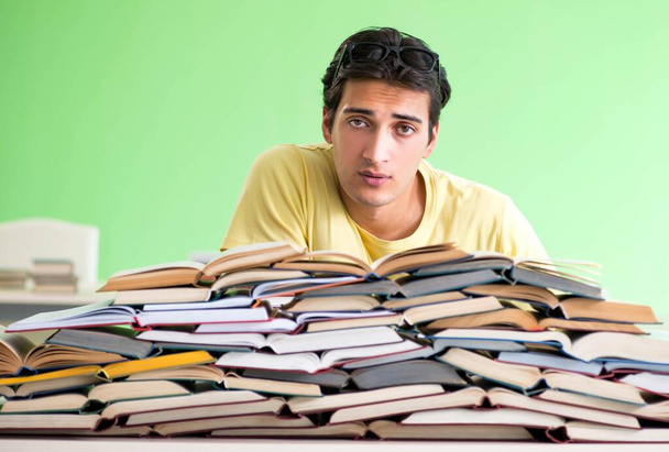 Studenten met te veel boeken om te lezen voor het examen - Foto, afbeelding