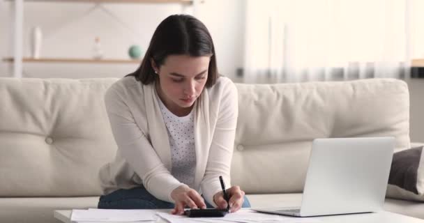 Young 20s woman calculating monthly budget at home. - Filmati, video