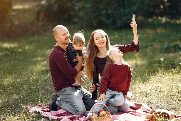 Family with cute kids in a autumn park - Fotó, kép