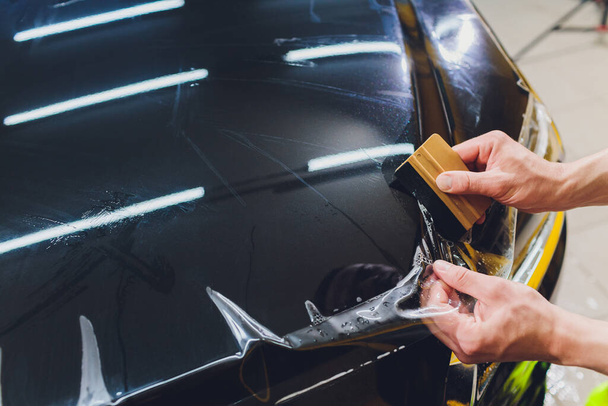 Transparent film, car paint protection, wrapping specialis. Car detailing. Selective focus. - Foto, Imagem