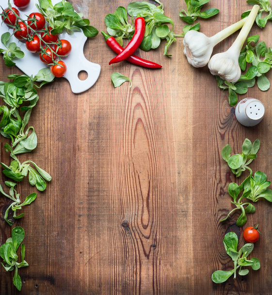 Healthy food background for recipes, menu or list with various fresh organic vegetables and condiment ingredients for salad or cooking on rustic wooden background, top view, frame. - Photo, image