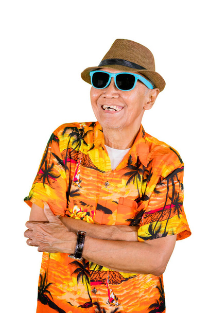 Happy old man wearing sunglasses and summer clothes while standing in the studio, isolated on white background - Fotó, kép