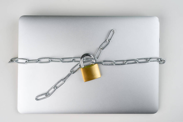 Hangslot met ketting op een laptop computer. Cybersecurity abstract concept. - Foto, afbeelding
