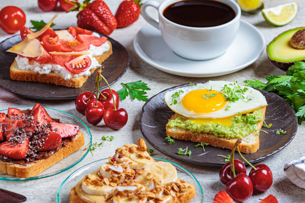 Breakfast different toasts with berries, cheese, egg and fruit, light background. Breakfast table concept. - Φωτογραφία, εικόνα