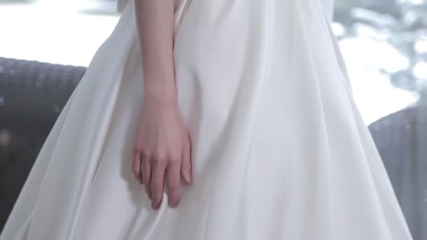 blonde aux cheveux longs essaie sur élégante robe de mariée en soie blanche - Séquence, vidéo