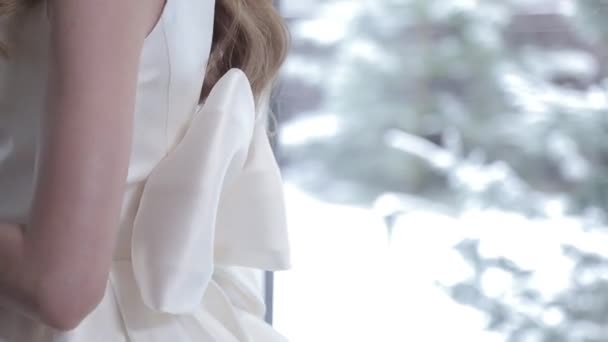 blonde dame pose en robe de mariée blanche avec arc sur le dos - Séquence, vidéo