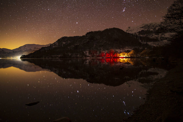 Uma noite de inverno em Ullswater com carros luzes traseiras refletindo no lago
 - Foto, Imagem
