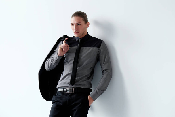 Portrait of a handsome man in a black suit who is posing over a white background - Photo, Image