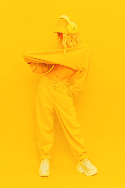 Hipster Girl posing in studio. Urban style. Hip-hop, dancer.Trendy Fresh casual outfit. Fashion yellow monochrome aesthetic colours. - Photo, Image