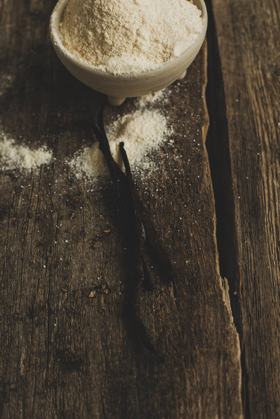 Palillo de vainilla y harina sobre la mesa - Foto, imagen