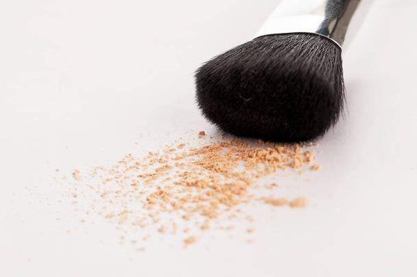 Cepillo natural de maquillaje con polvo beige sobre fondo blanco - Foto, imagen