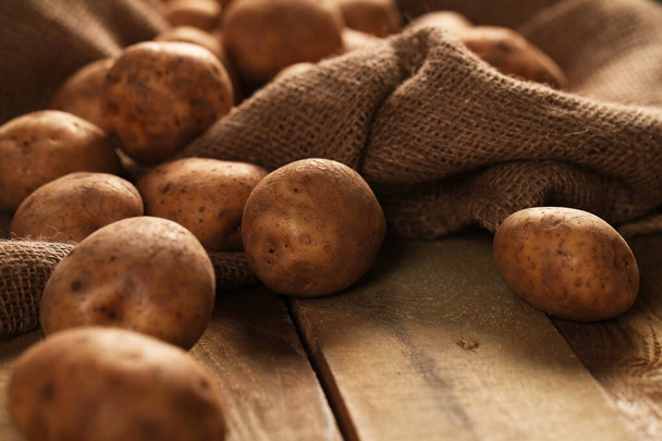 Rustikale frische, ungeschälte Kartoffeln auf einem Holztisch - Foto, Bild