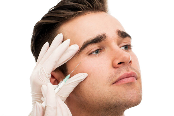 Plastiikkakirurgia. Komea mies valkoisella taustalla - Valokuva, kuva