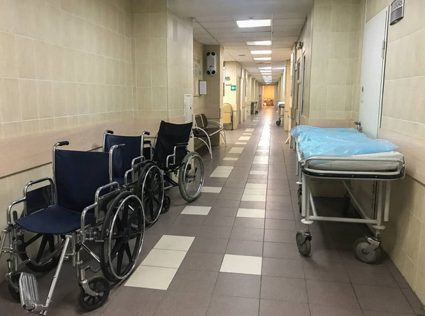 Госпітальне колесо стільців і візок у порожньому лікарняному коридорі
 - Фото, зображення