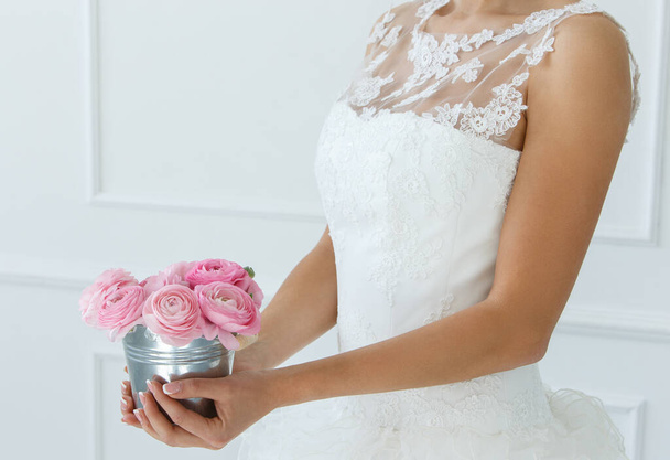 Γάμος. Ελκυστική νύφη κρατώντας κατσαρόλα με όμορφα τριαντάφυλλα - Φωτογραφία, εικόνα
