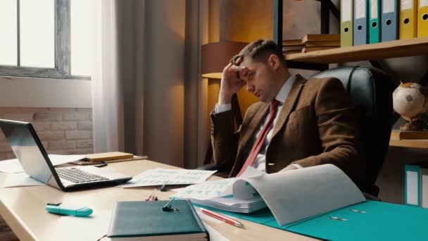 An upset, pensive businessman looks at the financial report. Problems with the business. - Filmati, video