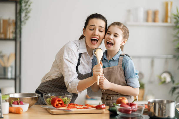 Healthy food at home. Happy family in the kitchen. Mother and child daughter are preparing proper meal. - Fotoğraf, Görsel