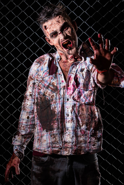 Creepy zombie on the fence background - Photo, Image