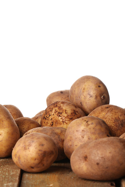 Pommes de terre fraîches non pelées rustiques sur une table en bois  - Photo, image