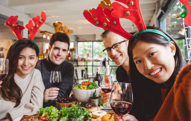 Bir grup genç Noel partisini bir bardak şarap ve selfie ile kutluyor. - Fotoğraf, Görsel