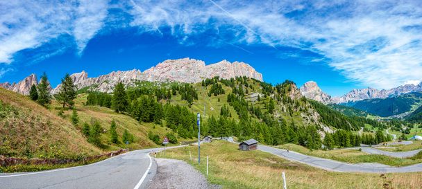 Panoramisch uitzicht vanaf Passo Gardena op magische Dolomieten toppen van Cima Cunturines en serpentine bergweg, Zuid-Tirol, Italië - Foto, afbeelding