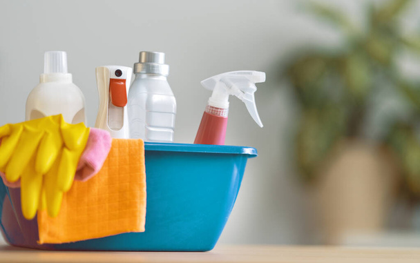 Basket with cleaning items on blurry background. - Foto, Bild
