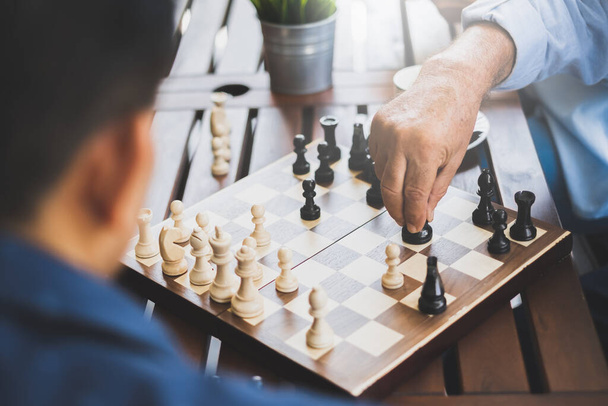Starszy pan gra w szachy na szachownicy dla strategii i koncepcji planowania - Zdjęcie, obraz