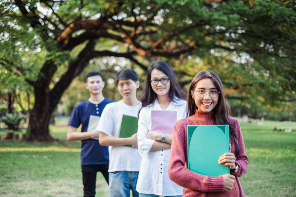 アジア系の若者が公園に立って教育の概念を学び - 写真・画像