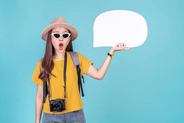 Mladá asijská žena batohem cestovatel držící řeč bublina pro text a reklamy přes modré pozadí, kopírovat prostor pro cestování koncept - Fotografie, Obrázek
