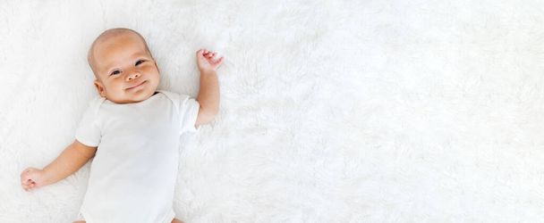 Portrét novorozeně šťastný nad bílým pozadím, horní pohled - Fotografie, Obrázek