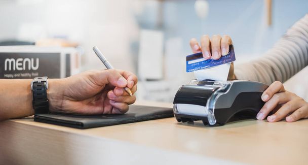 Πελάτης που χρησιμοποιεί το καλάθι πιστώσεων για την πληρωμή στον ιδιοκτήτη στο εστιατόριο cafe, τεχνολογία χωρίς μετρητά και πιστωτική κάρτα έννοια πληρωμής - Φωτογραφία, εικόνα