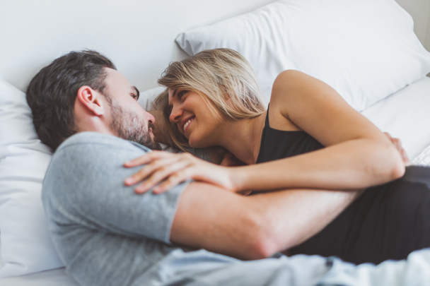 Šťastný pár milenec na posteli, objetí a polibek v romantické době, láska a vášnivý koncept. - Fotografie, Obrázek